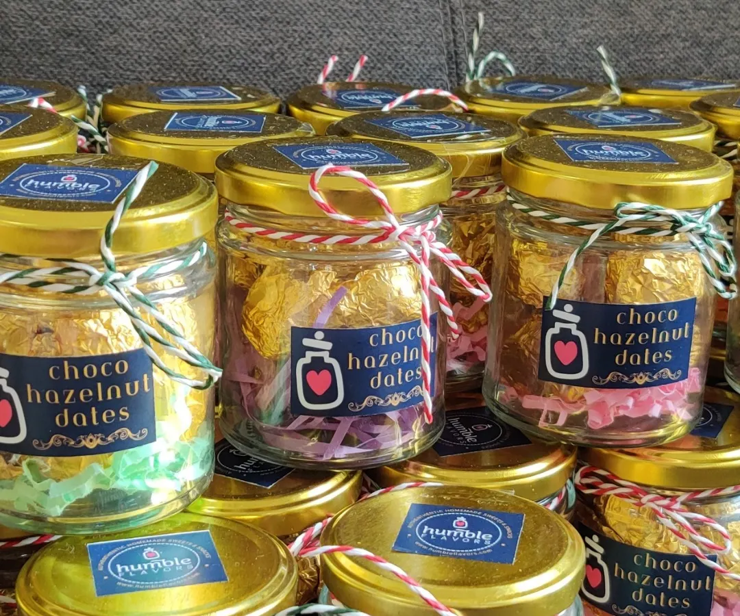 These Choco Hazelnut Dates are one of my most loved items for gifting. Each date is filled with a crunchy hazelnut, coated in chocolate, and wrapped by hand. They look beautiful in these little glass jars and make for a perfect, healthy indulgence for corporate events or festival hampers.