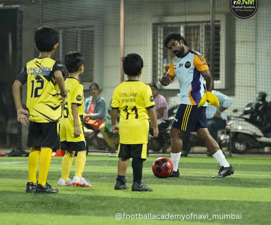 Coaching is about connection. Here, I'm breaking down a drill for my youngest players, making sure they understand the 'why' behind the 'what'. I believe individual attention is key to building a strong foundation.