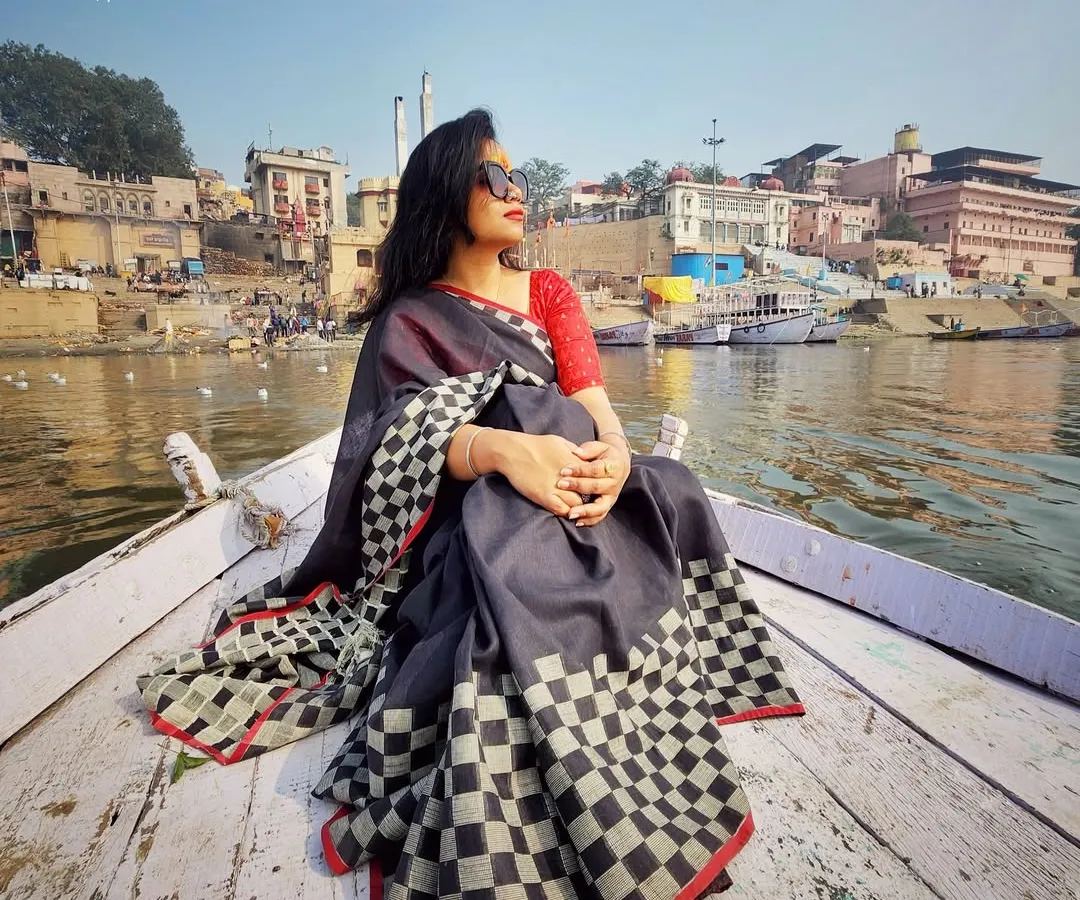 Style is a journey, not a destination. Here, on a boat in the serene ghats of Varanasi, a timeless checkered saree tells a story of heritage and grace. I help you find outfits that honor your roots while feeling completely modern.