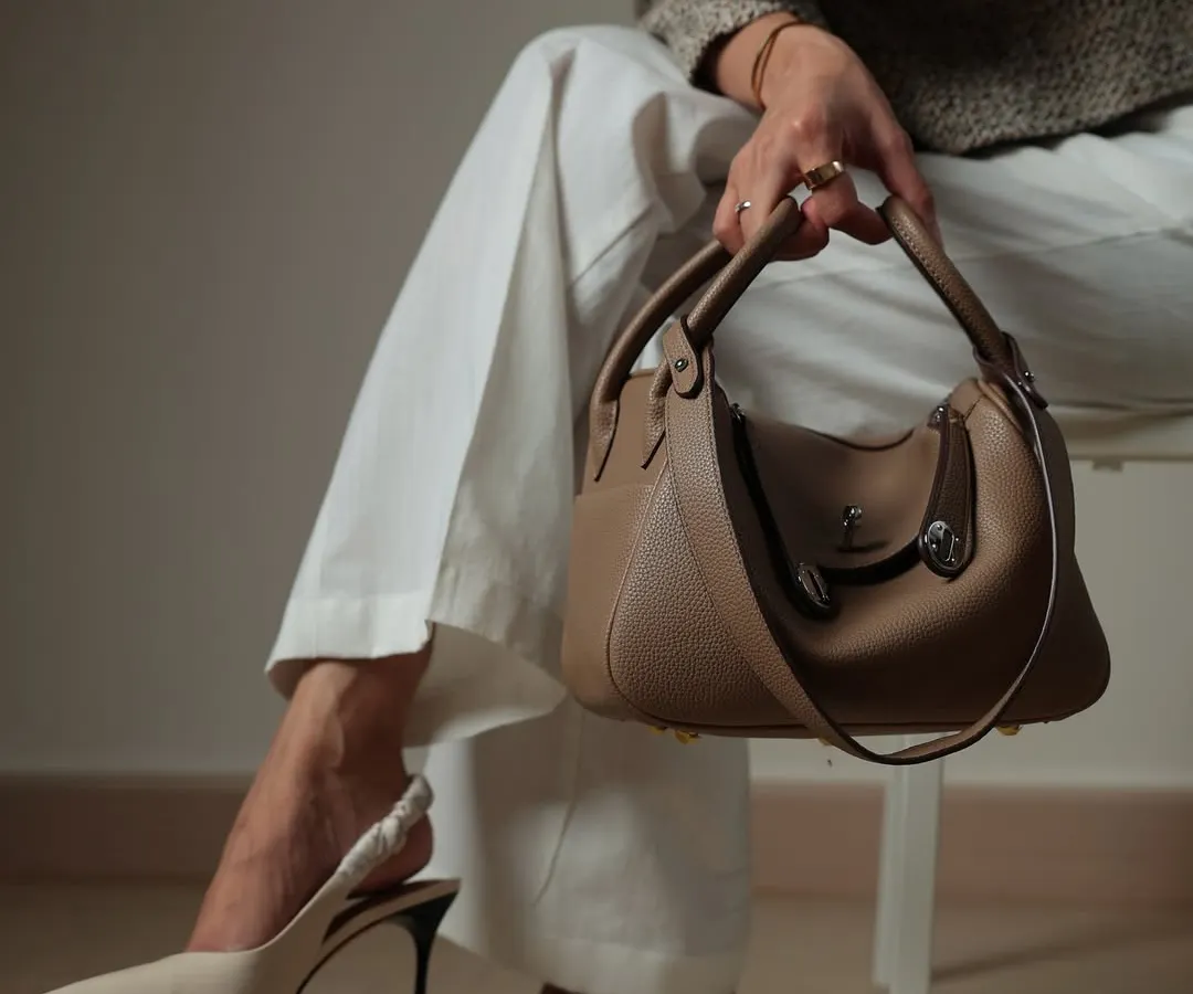 Here is the Linde Medium bag styled for a chic, elegant look. Paired with simple white trousers and heels, this taupe leather bag is versatile enough for both work and weekend outings.