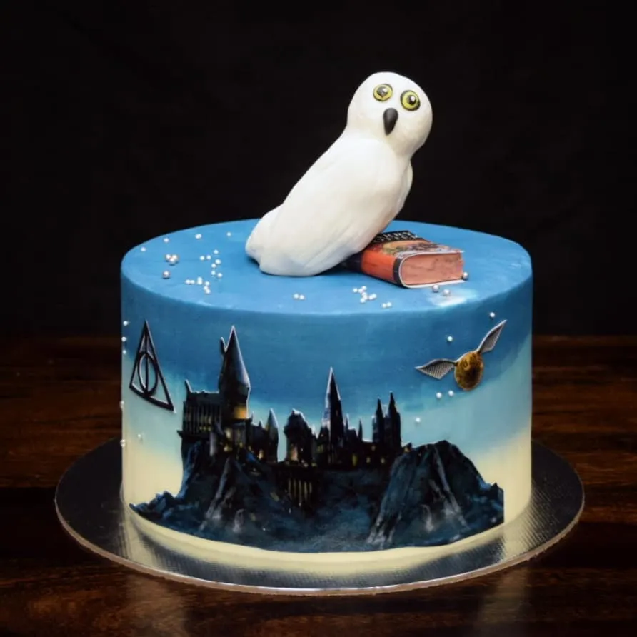 For all the Potterheads, this one's for you. I hand-painted the Hogwarts silhouette onto this cake and topped it with a fondant Hedwig and a golden snitch. It’s a magical centerpiece for any Harry Potter themed celebration.