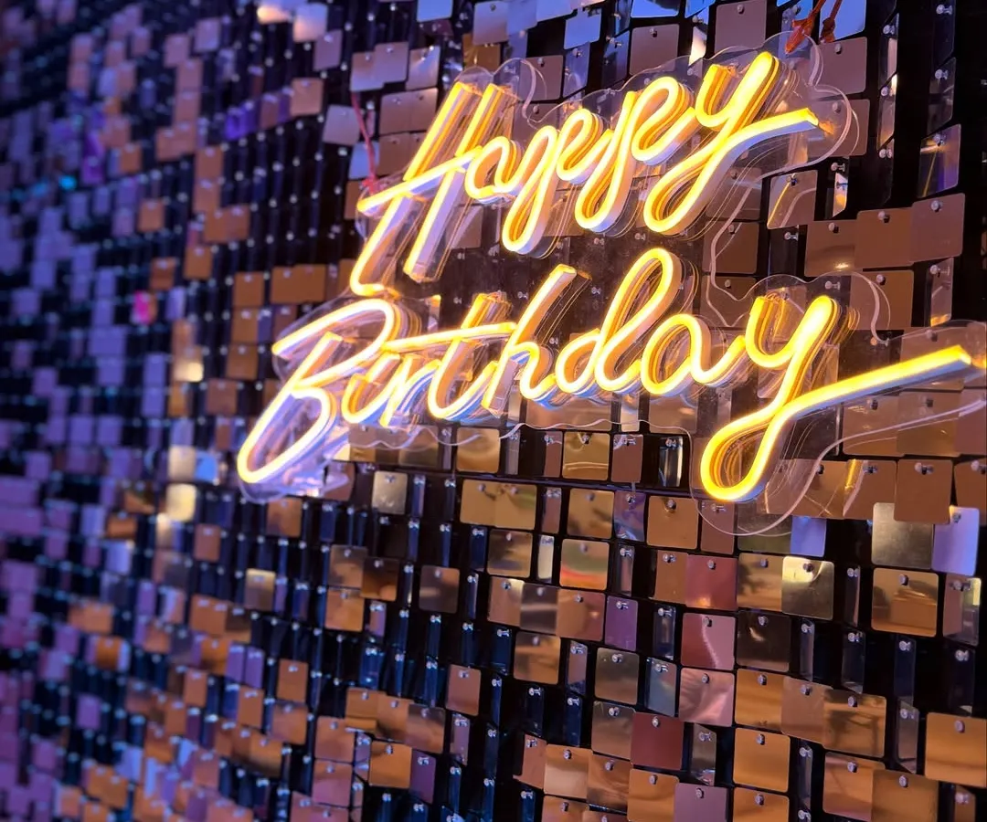 There's nothing like the sparkle of a shimmer wall. Here is a close-up of a custom neon sign against a gold sequin backdrop, creating a warm, inviting glow that makes any celebration feel extra special. This is a fantastic option for an anniversary or milestone birthday party.