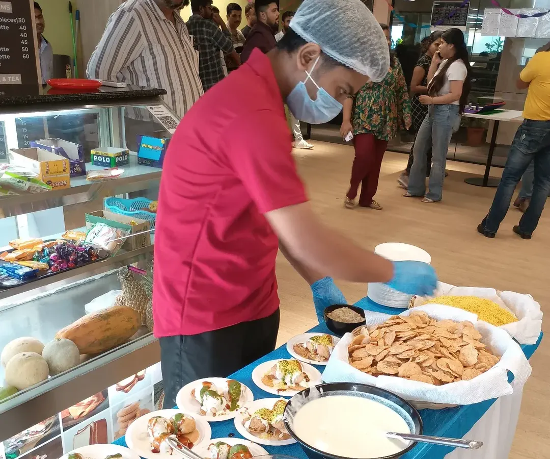 We bring the fun to your event with interactive live food stations. Here, our chef is preparing fresh dahi papdi chaat at a corporate party, allowing guests to customize their snacks just the way they like them. It’s a great way to add energy and engagement to any celebration.