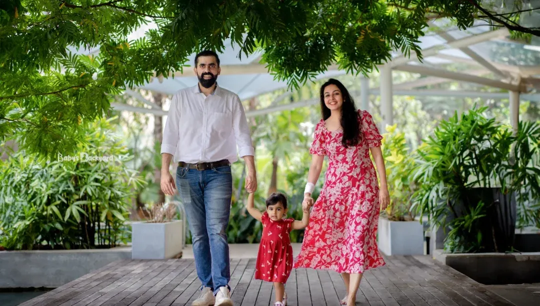 A happy family strolls hand in hand through a lush Bangalore park. We believe the most magical family portraits happen during these natural, unposed moments of togetherness.