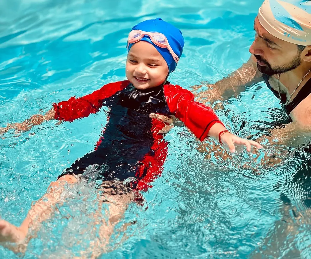 Safety and trust are the foundation of our teaching. Here, one of our certified coaches provides hands-on support, helping a young swimmer learn to float and feel secure in the water.