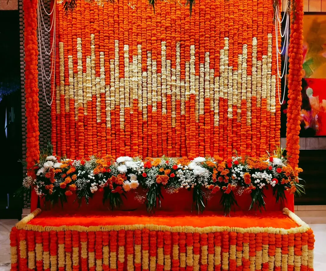 We created a stunning floral soundwave pattern using thousands of fresh marigold and tuberose flowers for this large-scale backdrop. This unique design shows how we can transform traditional flowers into a modern art piece, making it a vibrant and memorable focal point for any event.