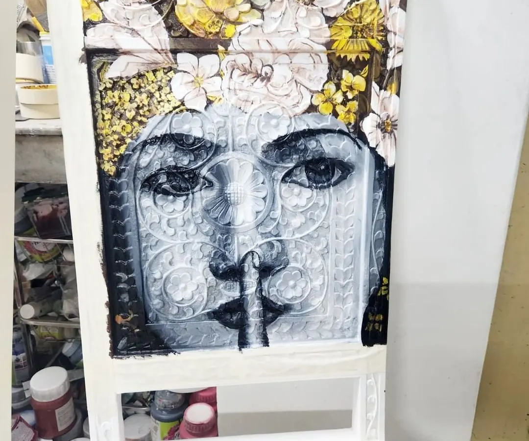 We turned a simple chair into a piece of functional art. This is an in-progress shot of a hand-painted portrait, featuring a woman crowned with yellow and white flowers, showcasing our ability to add intricate, artistic detail to everyday furniture.