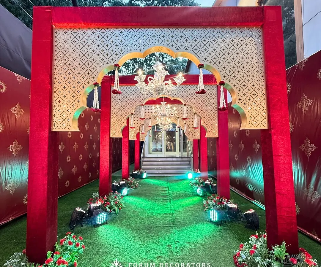 For a truly grand and royal statement, I designed this opulent red and gold entrance. The layered arches with traditional motifs, velvet textures, and brilliant chandeliers create an unforgettable first impression for a regal shaadi.