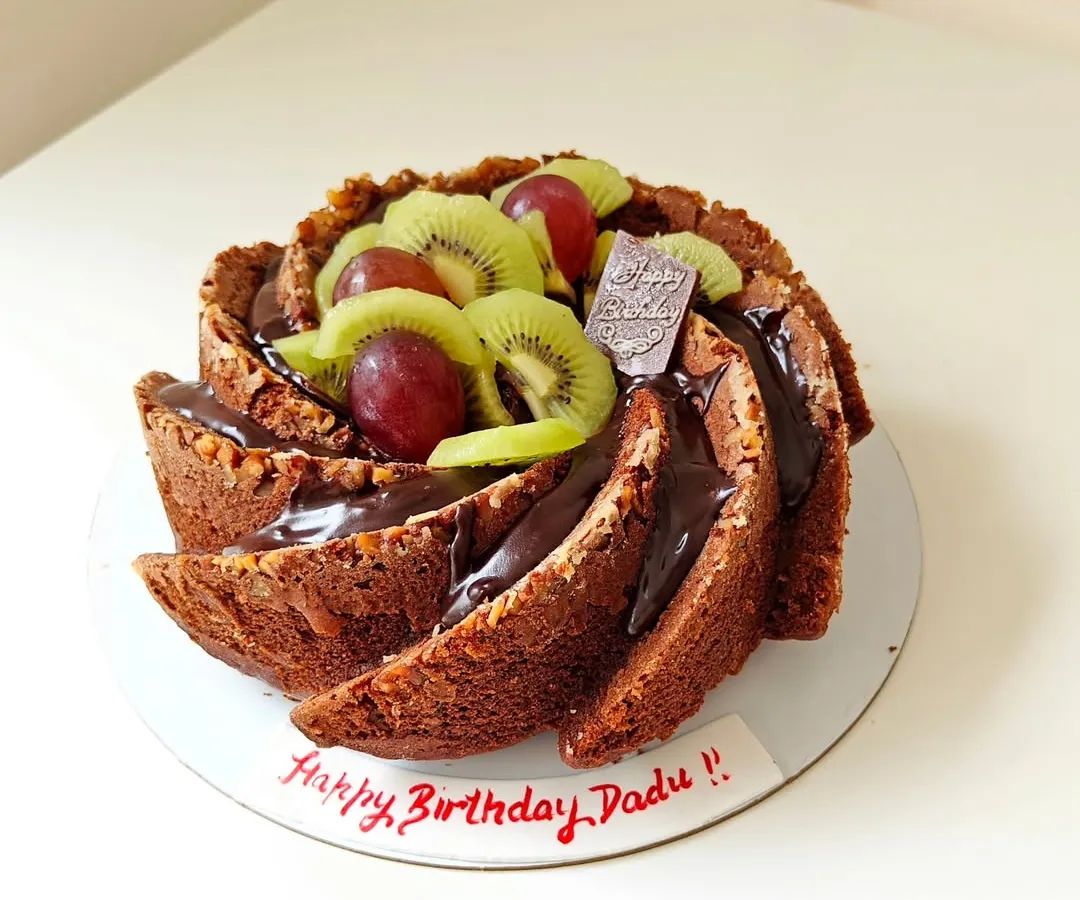 This is a perfect example of my wholesome baking, a whole wheat Bundt cake made for a birthday. It's topped with a rich chocolate ganache, fresh kiwi, and grapes, proving that healthy can be celebratory and delicious.