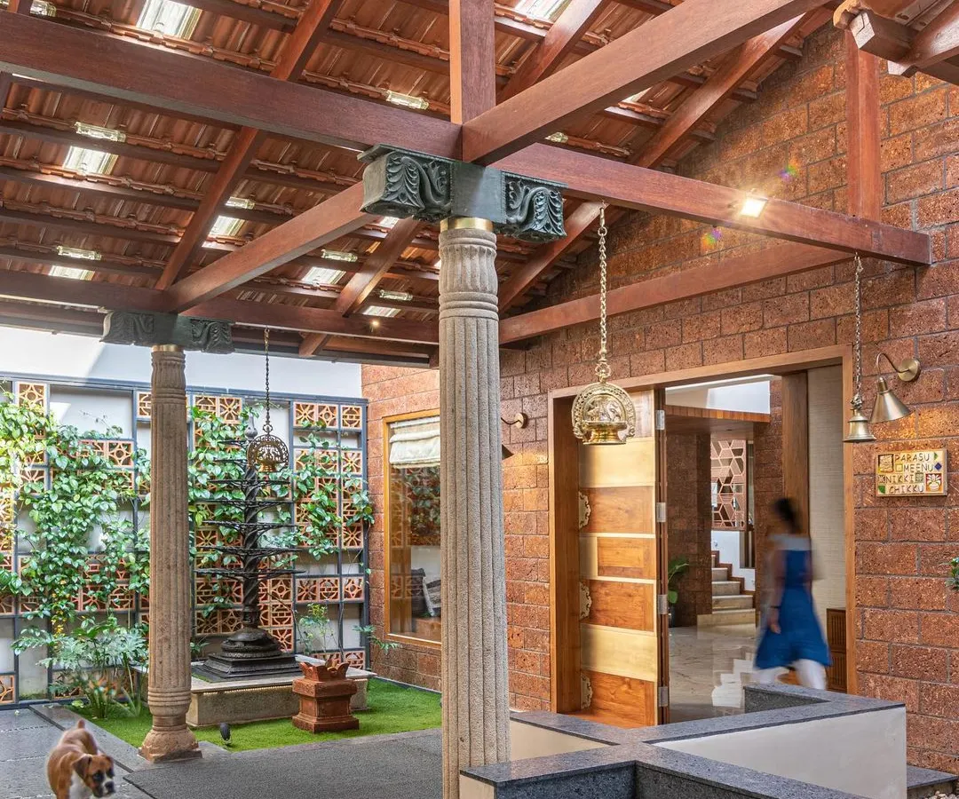I love creating modern interpretations of the traditional Indian courtyard. Here, reclaimed wooden pillars and a terracotta tile roof frame a central green space, making for a grand yet welcoming entrance that feels rooted in heritage.
