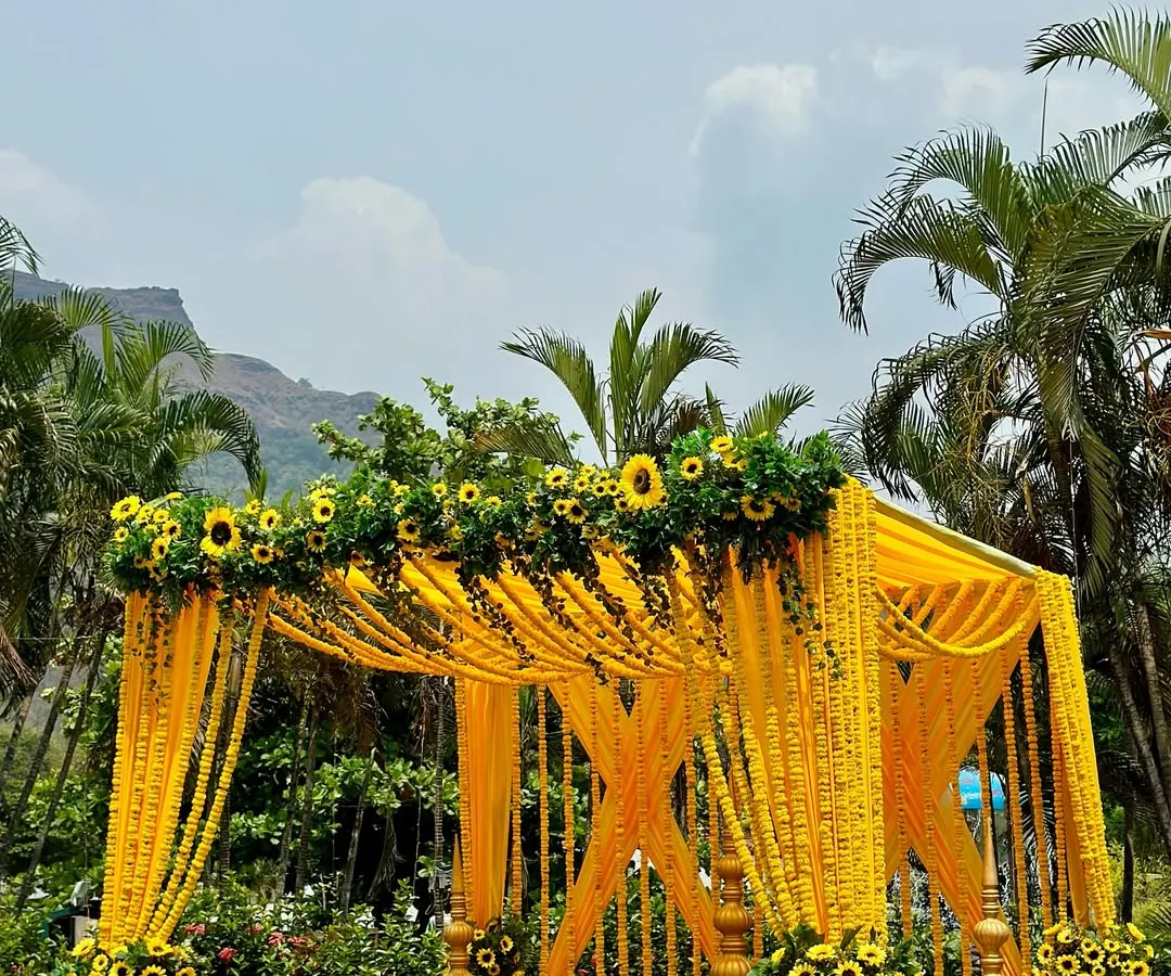 For this outdoor Haldi ceremony, we built a stunning mandap drenched in vibrant yellow. The structure is heavily decorated with marigold garlands and fresh sunflowers, creating a traditional and cheerful atmosphere against a beautiful natural backdrop.