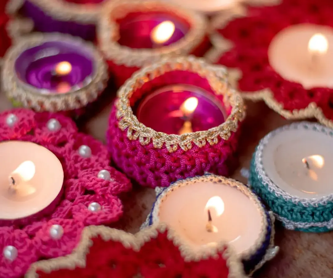 Our handmade crochet diya holders glowing warmly, creating a perfect festive ambiance. This collection includes various designs like beaded coasters and simple jackets, all crafted to make your Diwali celebrations brighter and more personal.