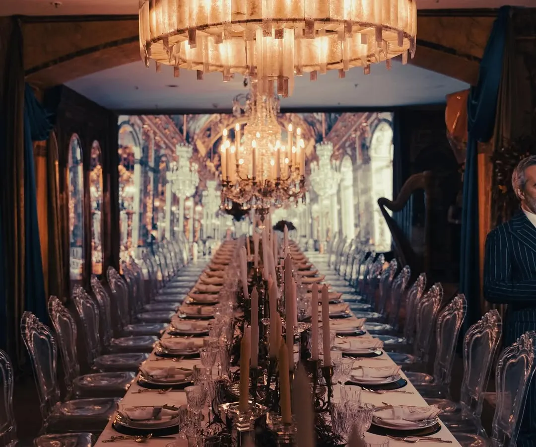 A breathtaking view of our tablescape for an event inspired by the Château de Versailles' Hall of Mirrors. The endless table, dramatic chandeliers, and warm candlelight created an opulent and truly immersive dining atmosphere.