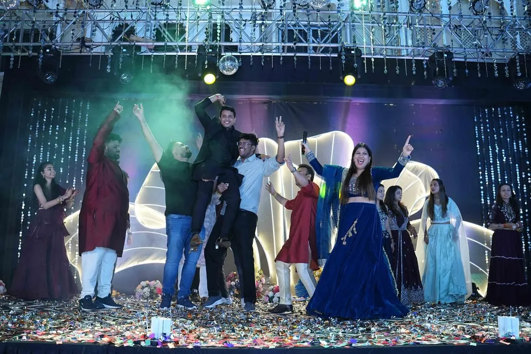 A Sangeet night is all about celebration. Here I am with the groom's squad, hyping them up on stage with confetti, smoke, and unstoppable energy.
