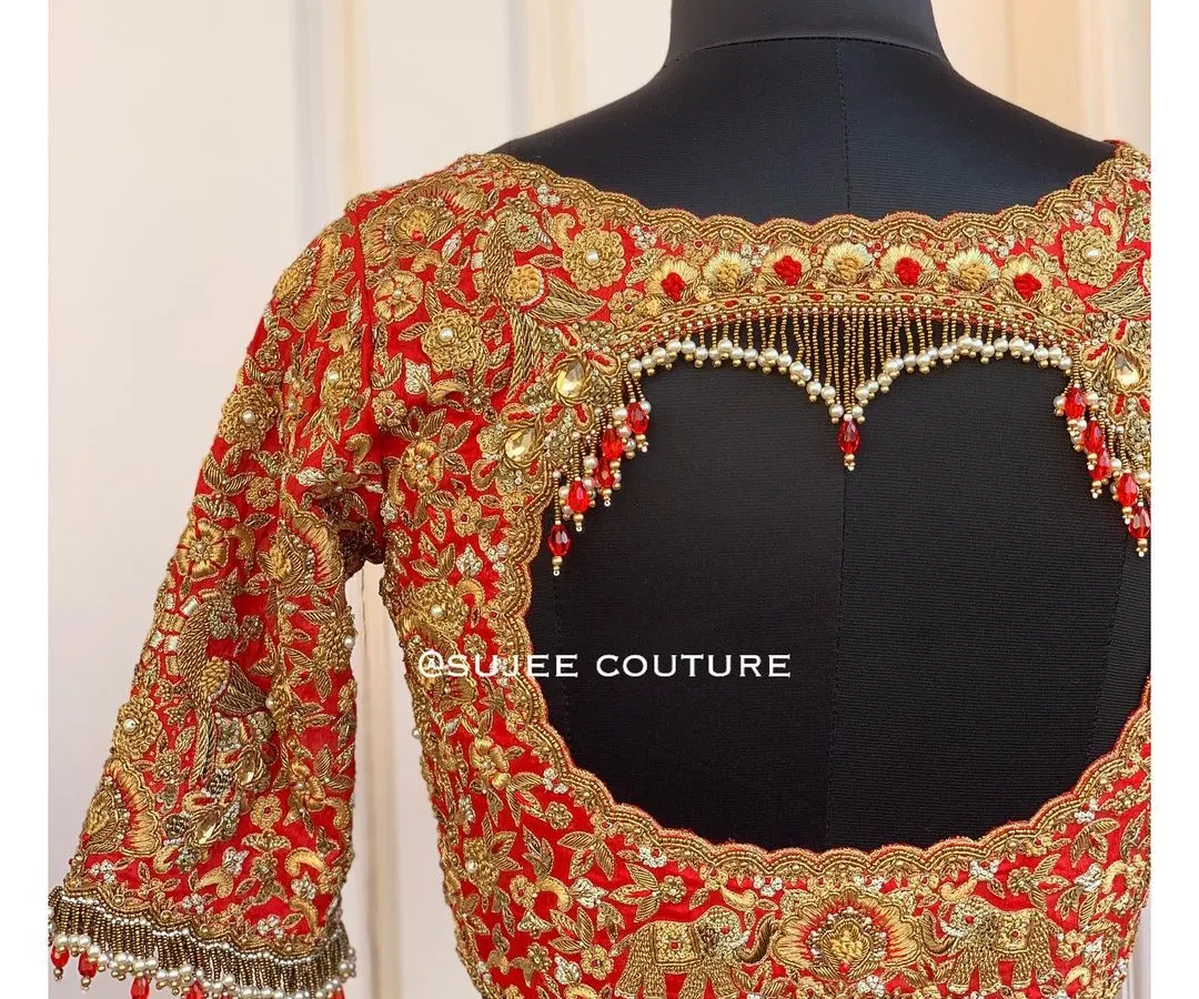 I love creating designs that make a statement. This bold red bridal blouse features a dramatic heart-shaped back cutout, heavily embellished with zardozi and finished with delicate pearl tassels for a truly unforgettable look.
