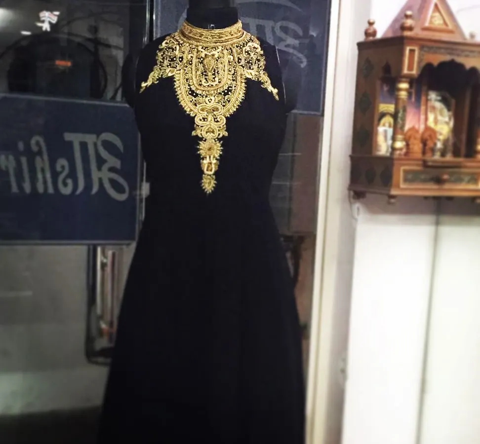 For a touch of shaadi party glamour, this black Indo-Western rental outfit is a showstopper. The high collar features intricate Zari and Dabka handwork for a truly regal look.