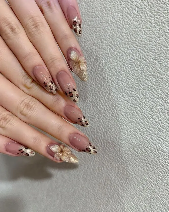 For a look that's both fierce and delicate, I hand-painted this leopard print on sharp, stiletto-shaped gel extensions. The design is balanced with a beautiful, sculpted 3D acrylic flower on the accent nail.