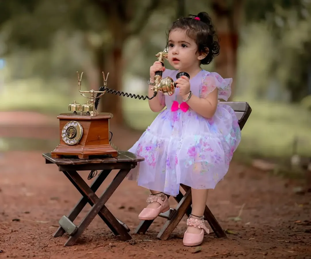I love creating these whimsical scenes. Here, little Naira is having a very important conversation on a vintage rotary phone during her themed portrait session. It is these playful, imaginative moments that make for unforgettable baby photography.