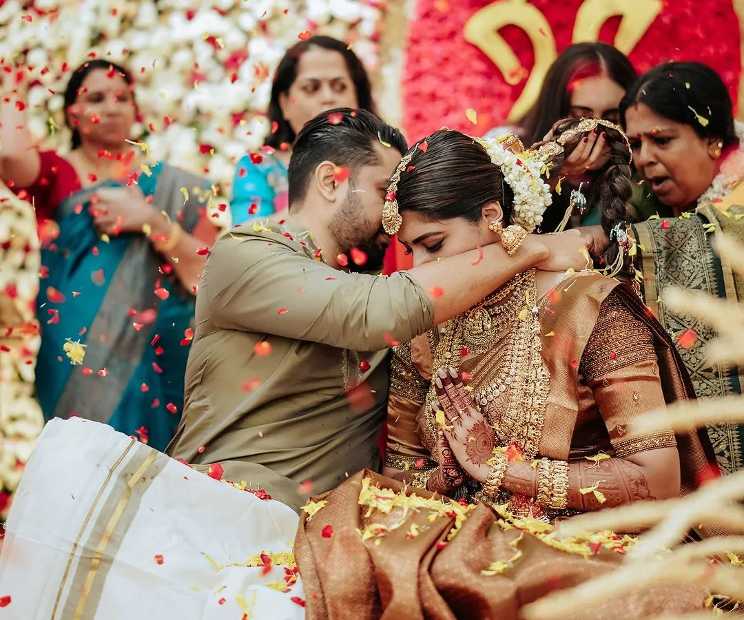 In a shower of fragrant petals, Sradha and Vinay share a sacred moment during their Hindu wedding ceremony. Capturing the pure joy and traditional blessings is what makes a wedding film truly timeless.