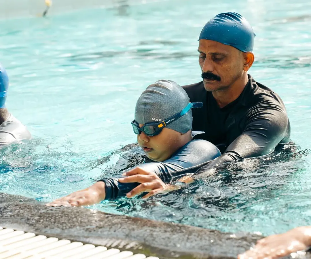 For me, coaching is personal. I take the time to provide one-on-one adjustments, ensuring every swimmer, like this young student, understands the feel of a correct stroke. This attention to detail is key to building a strong foundation.