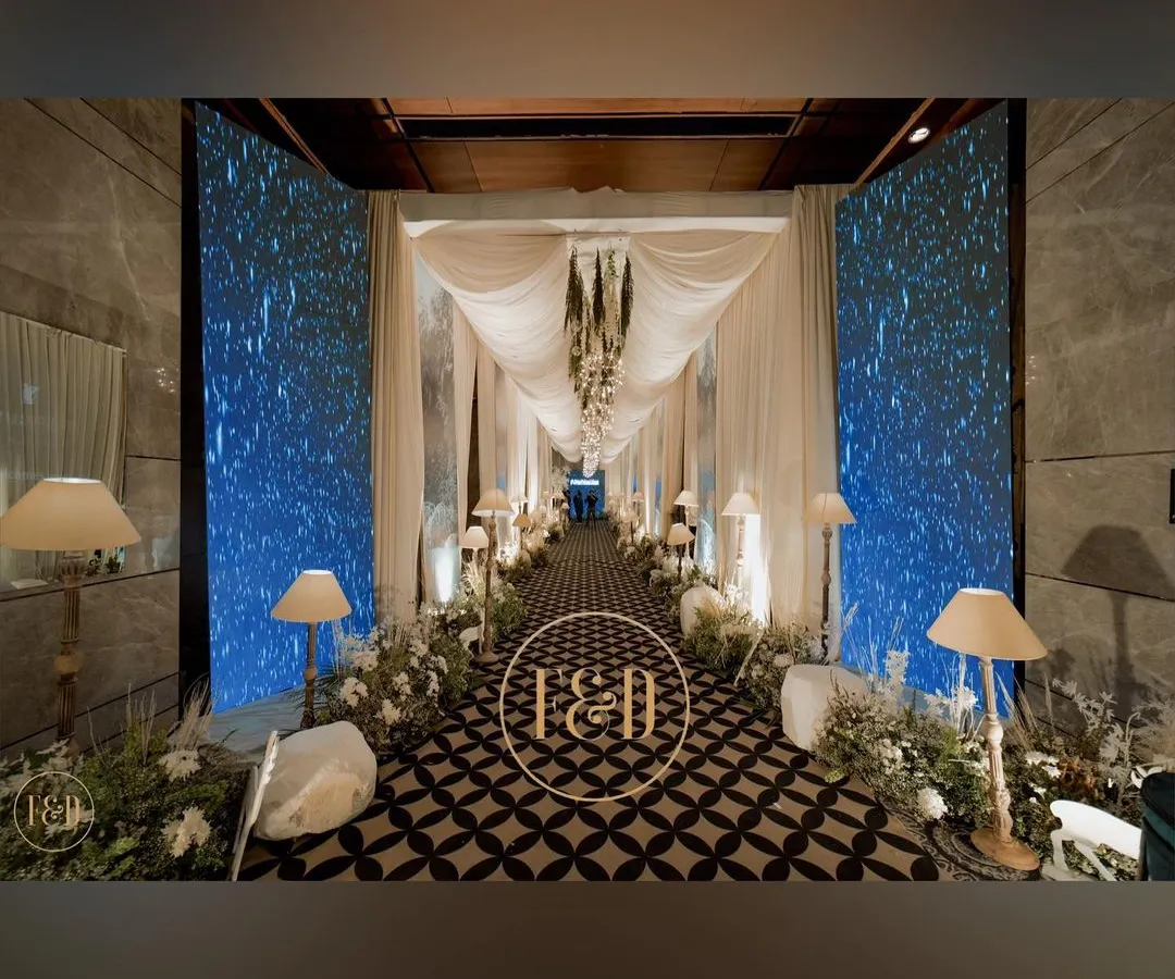 I designed this dramatic entrance to transport guests into another world. The combination of flowing white drapes, custom geometric flooring, and immersive blue LED walls created a grand and surreal welcome for this Sufiyana-themed evening.