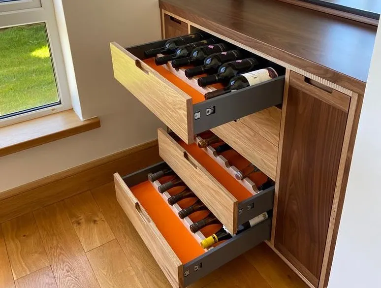 A closer look at the custom wine storage drawers. These are built with solid oak fronts and feature a vibrant orange lining for a personal touch. Each drawer is designed for easy access and secure storage of your wine collection.