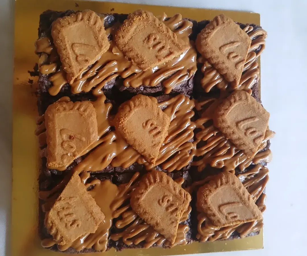 A batch of my fudgy Biscoff brownies, ready to be packed. Each square is rich, dense, and topped with a generous drizzle of Biscoff spread and a crunchy Lotus biscuit. It's one of my most requested eggless brownie flavors.