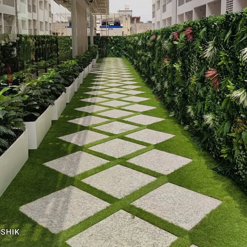 A complete outdoor landscaping project for a leading fashion brand's retail store. This installation features a premium artificial green wall, a diamond-patterned walkway with artificial turf, and potted plants, creating an immersive and maintenance-free green experience.