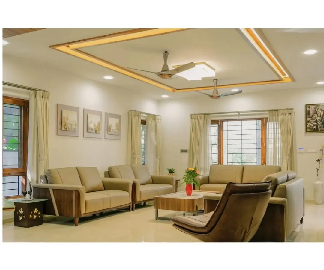 A view into a modern living room where functionality and comfort are key. The design uses a warm, neutral palette, clean lines, and thoughtful lighting, including a recessed ceiling feature, to create an inviting and spacious family area.