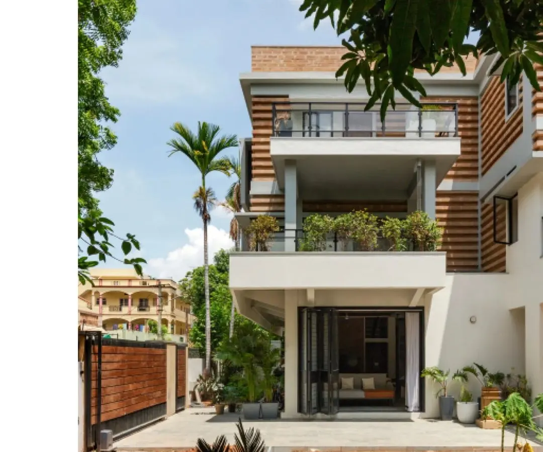 The renovated and extended Ananda residence in Hyderabad, showcasing a facade of striated compressed earth blocks. This design choice was not just for aesthetics but also for thermal comfort, creating a self-shading pattern that reduces heat gain.