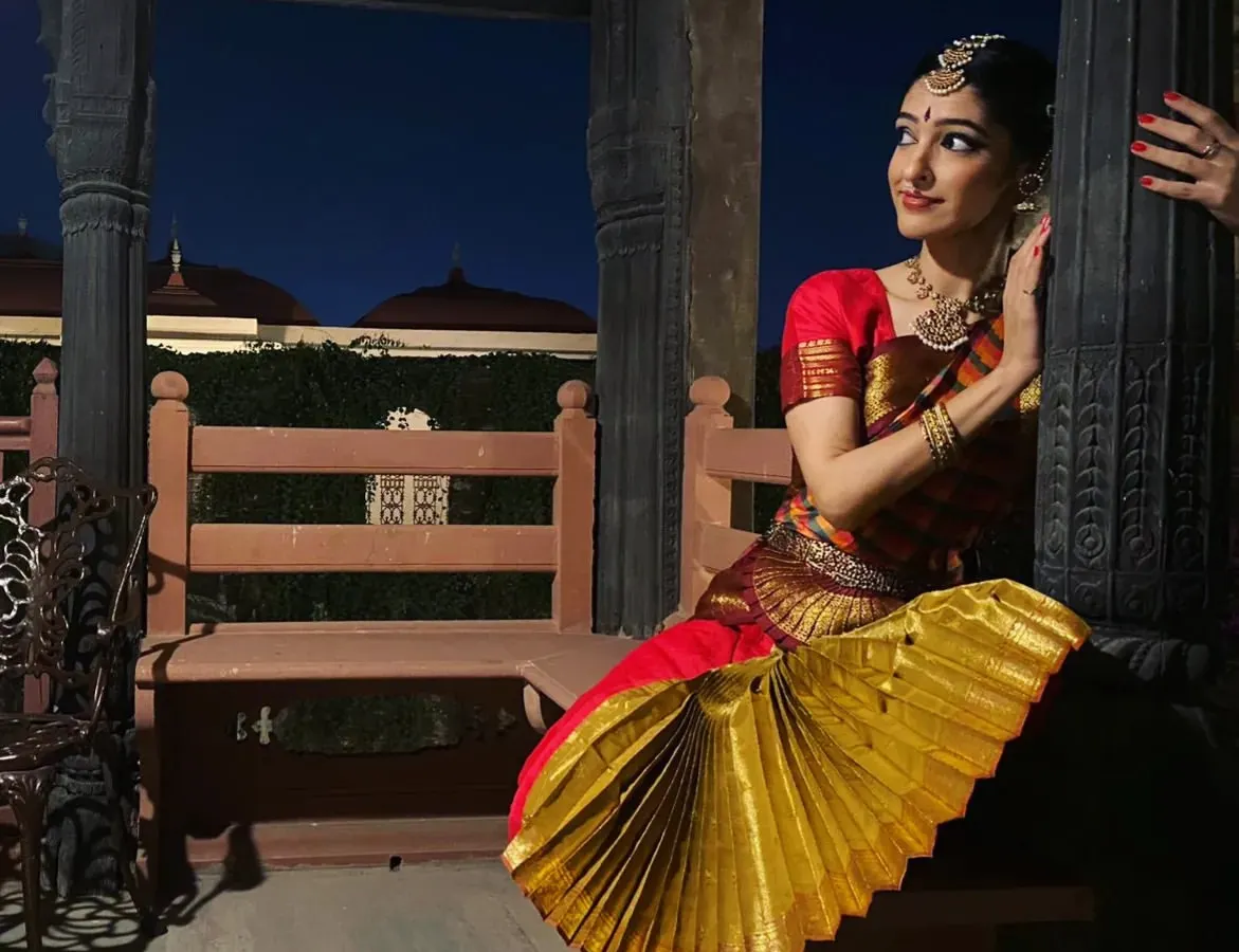 A classic Bharatanatyam pose captured during a performance. The fan-like pleats of the costume and the specific hand gesture, or mudra, are essential elements of this traditional Indian dance form.