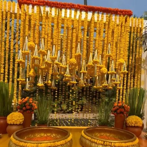 We love bringing the vibrant energy of a Haldi ceremony to life. This setup features a dense wall of fresh marigolds (genda) and traditional brass urlis, creating a picture perfect, sun-kissed setting for your pre-wedding festivities.