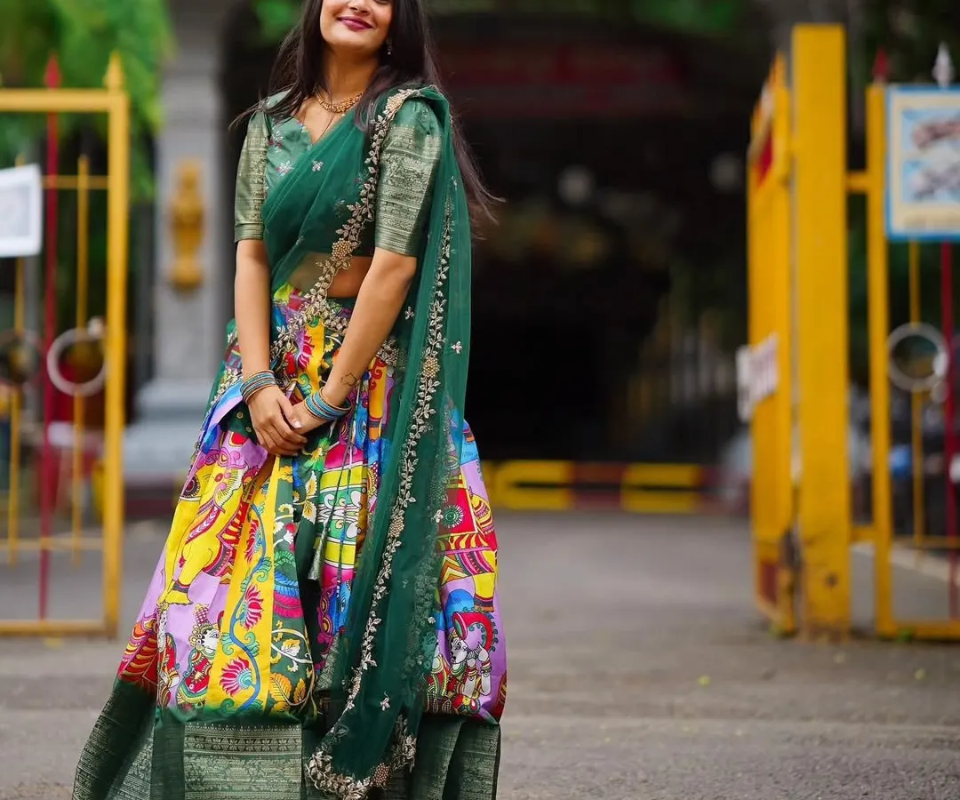 I love the blend of tradition and art in this Kalamkari-style Langa Davani. The vibrant, multi-colored skirt paired with a deep green blouse makes it a unique and eye-catching choice for festive events or cultural celebrations.