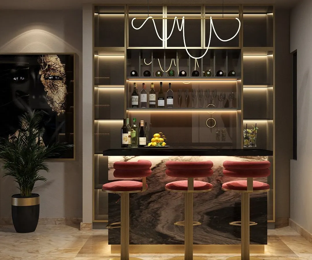We design spaces that set the perfect mood, like this custom home bar. It features a black marble top, plush velvet stools, and integrated backlighting that highlights the bottle display and glassware, creating a sophisticated corner for entertaining.