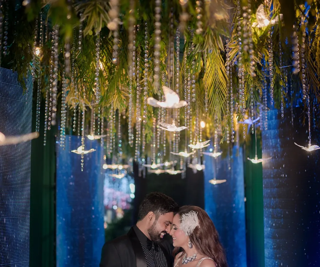 We love designing unique themes that tell your story. For this celestial sangeet, we created an enchanted pathway with hanging crystal birds and atmospheric lighting, making the couple's entrance feel like a walk through the stars.