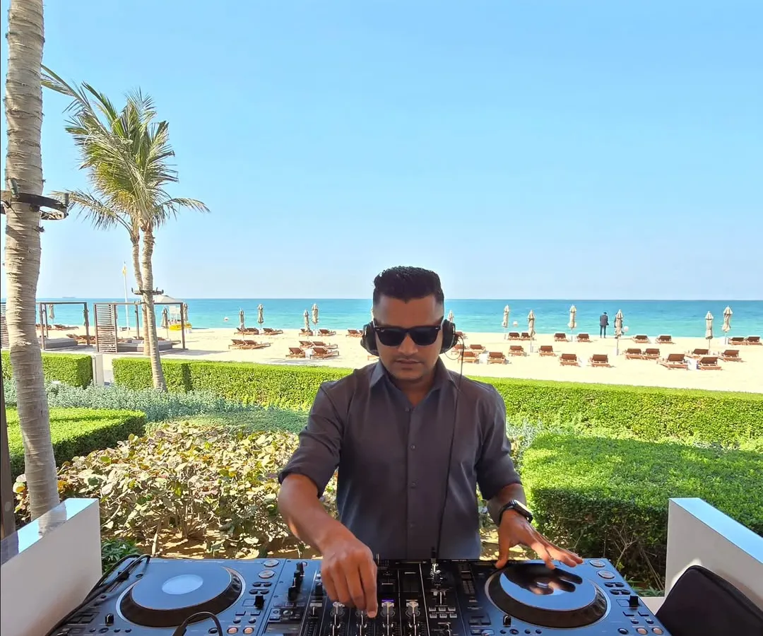 A daytime beach event requires a completely different energy. Here I am at a sundowner in Dubai, curating a relaxed yet groovy playlist as the sun sets over the ocean. It's all about matching the music to the mood.