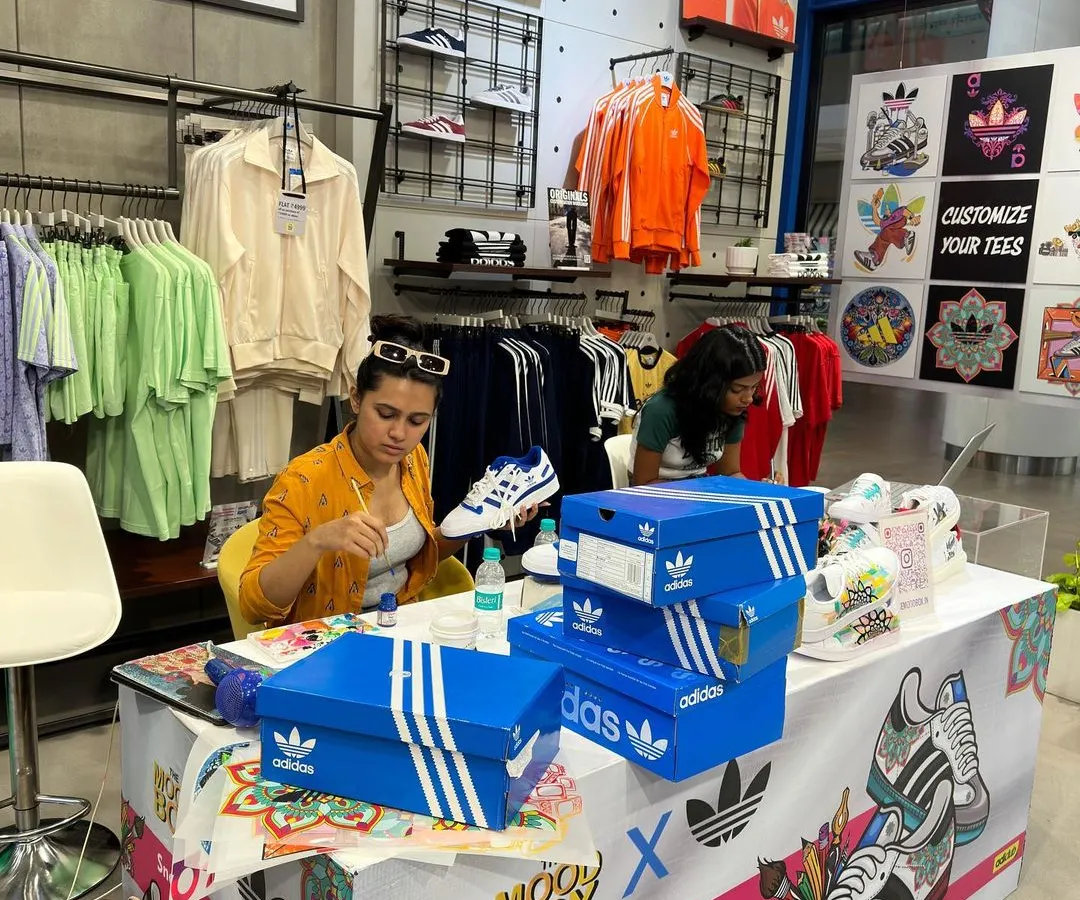 Here I am in my element at the Adidas flagship store, setting up for a live sneaker customization workshop. This is what it looks like when I bring an interactive art station to an event, surrounded by paints, brushes, and fresh pairs of shoes ready for a makeover.
