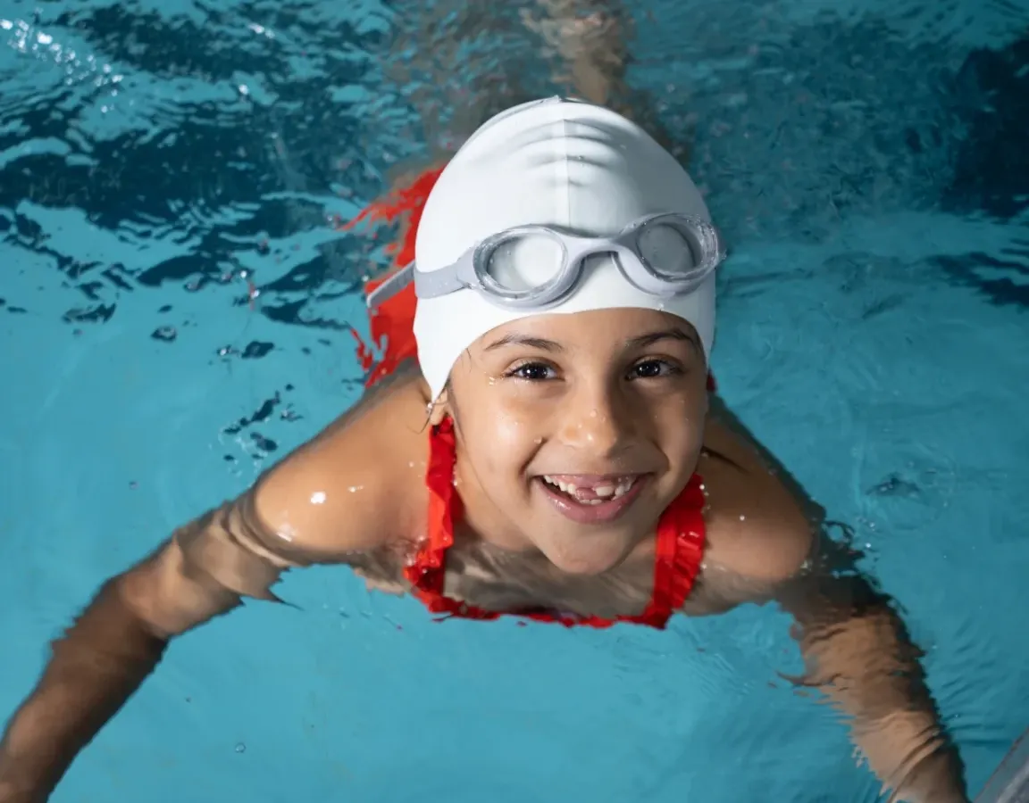 Look at that smile! This is what pure joy in the water looks like. Our swimming program for kids focuses on building confidence and having fun, one happy splash at a time.