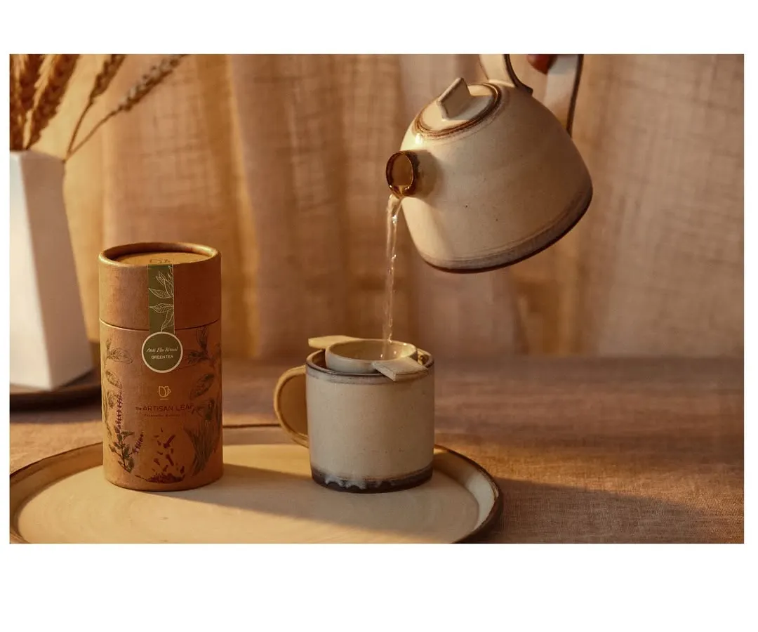 Capturing the quiet ritual of brewing artisanal tea. This image highlights the elegant product packaging while the action of pouring water adds a dynamic, sensory element to the visual story.