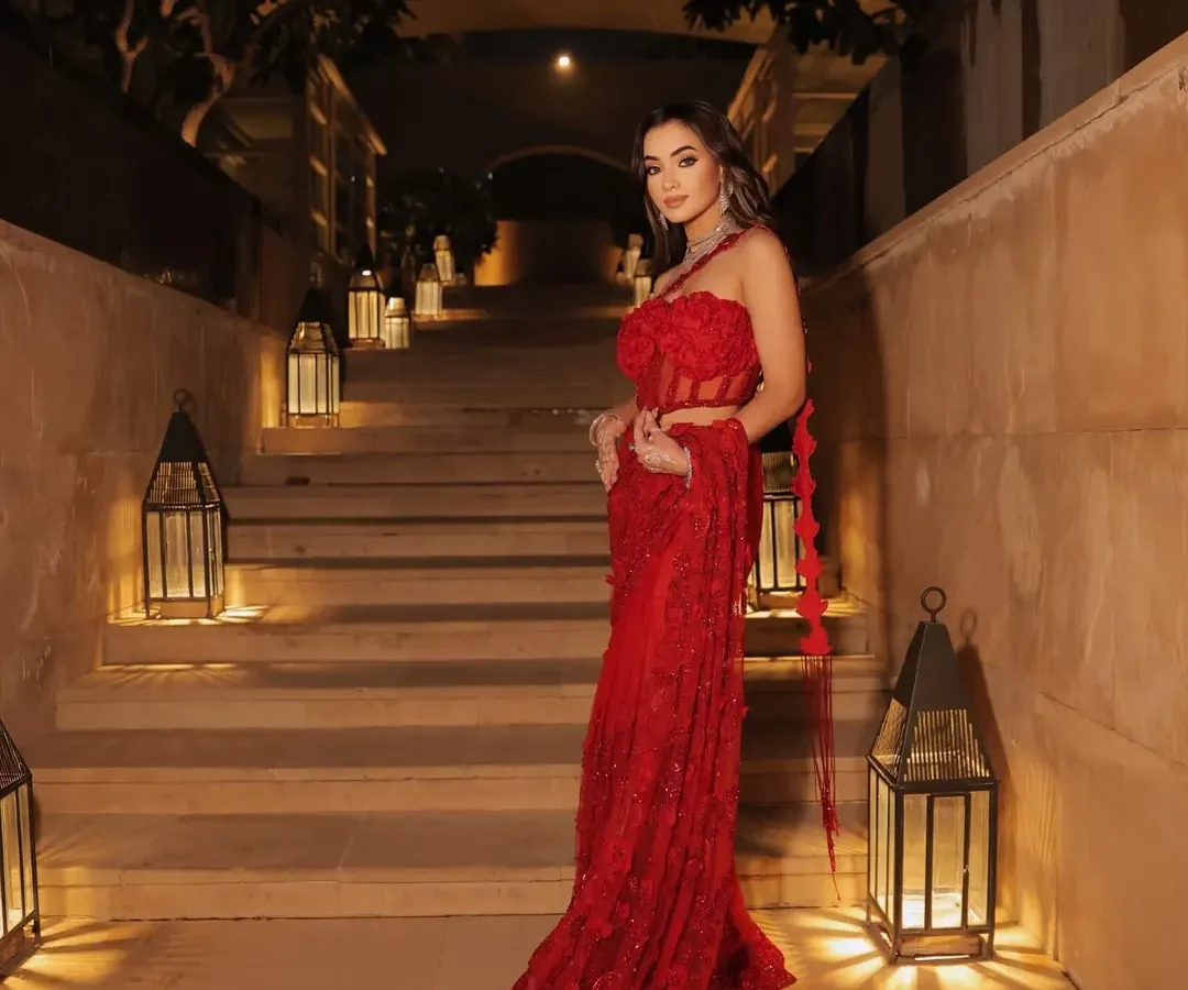 For a dramatic red carpet moment, I curated this breathtaking red couture saree-gown. The long, flowing train and intricate floral appliqué on the bodice create a powerful silhouette that is designed to turn heads.