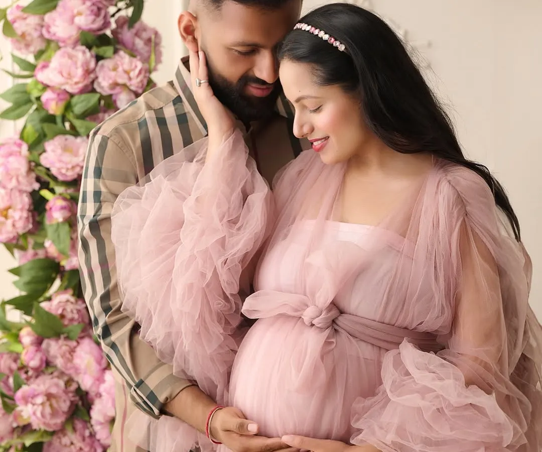 We believe maternity photos should be as magical as the life you're creating. In this fine-art maternity portrait, we used a cascade of pink peonies and a flowing tulle gown to create a dreamy, romantic atmosphere for the expecting couple.