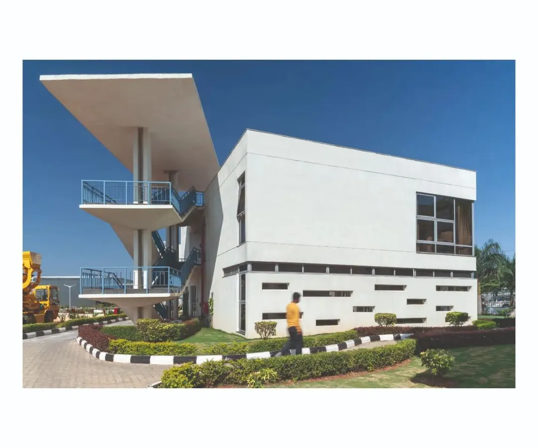 At the Ajax Engineering campus, individual buildings like this cafeteria and cloakroom are designed as distinct architectural forms that contribute to the whole. The cantilevered roof and strategic window placements are not just aesthetic choices; they are part of the larger campus identity.