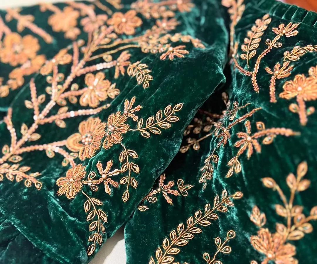 We believe in the power of details. Here, you can see the intricate gold zardosi embroidery, with delicate sequins and French knots, coming to life on a rich emerald green velvet fabric.