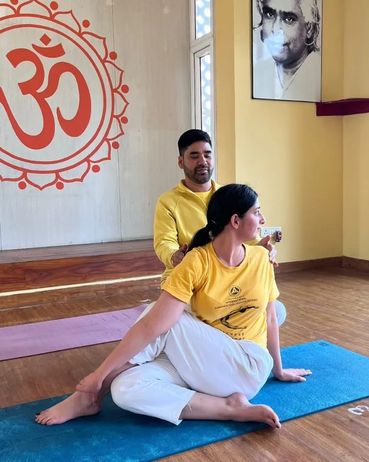 We believe in proper alignment to ensure a safe and effective practice. Our instructors provide personal, hands-on adjustments, helping you deepen your understanding of each asana, like this Ardha Matsyendrasana (Half Spinal Twist).