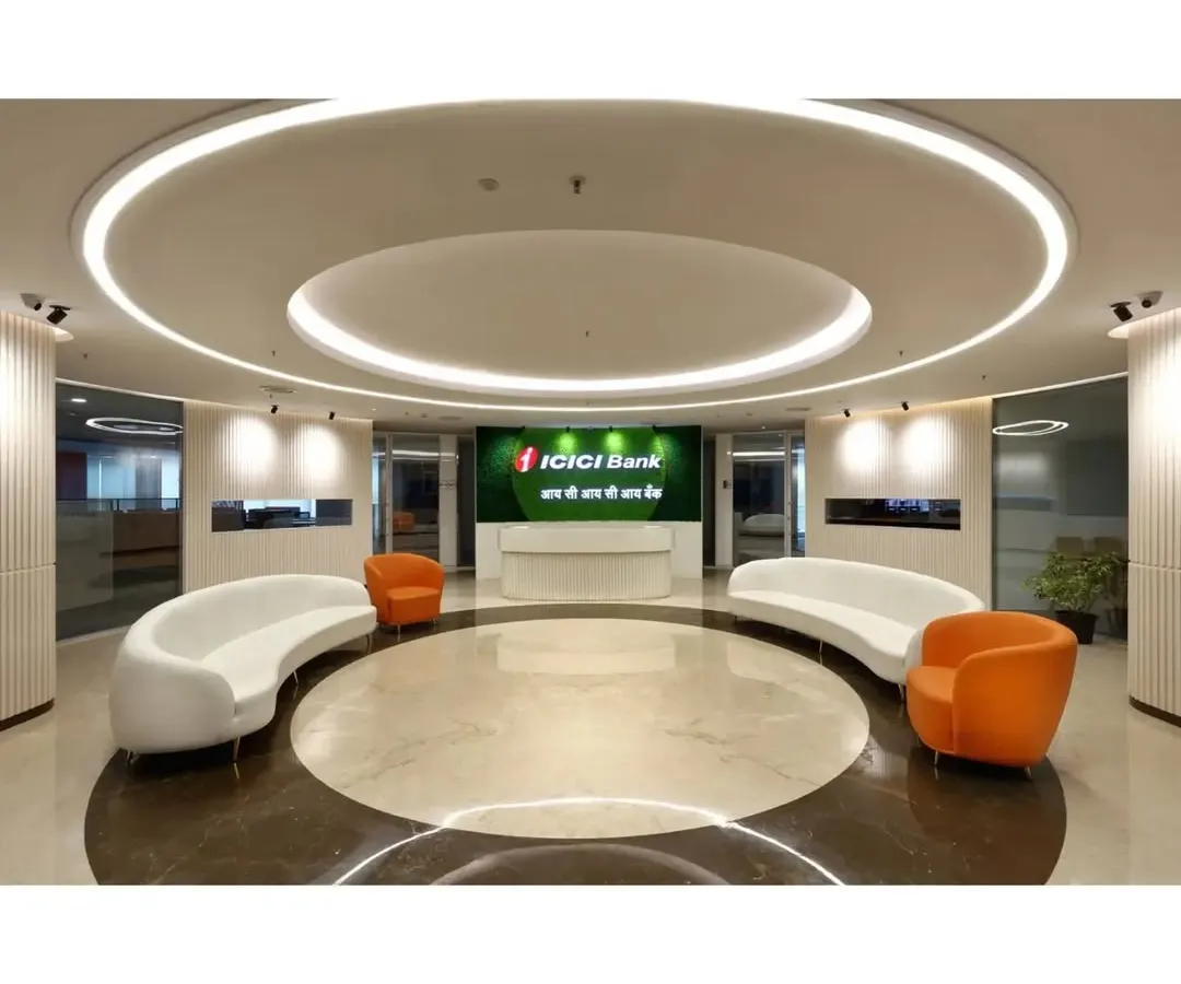The grand reception lobby we designed for ICICI Bank, featuring a circular layout, bespoke curved seating, and layered ceiling lights to create a powerful first impression. This space embodies modern corporate authority and a welcoming visitor experience.