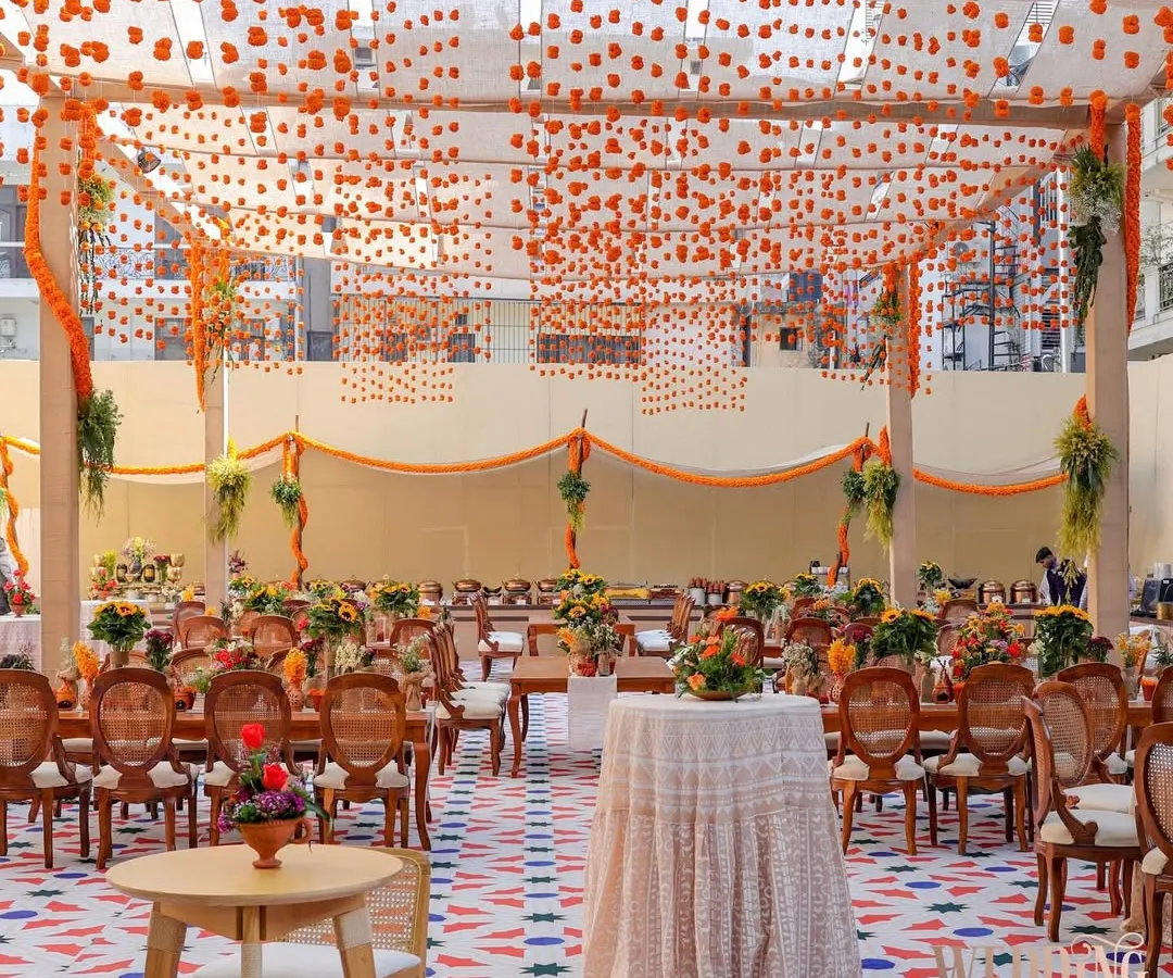 We brought the vibrant soul of Old Delhi to a sun-drenched brunch. This wide view captures the full experience, from the custom-printed flooring and tented ceiling with hanging marigolds to the comfortable seating areas, creating a perfect setting for a festive chaat party.