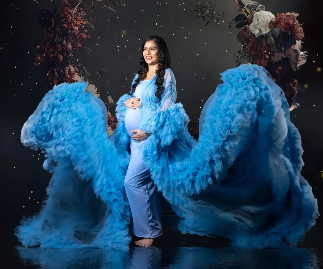 I created this magical, dreamy look right in my studio. The flowing blue gown, the dark floral ring, and the water reflection effect all come together to make the mom-to-be look like a goddess. This shows how we can create fine art maternity portraits.