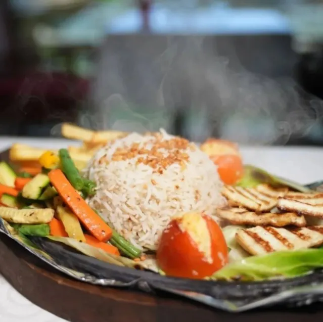Hear that sizzle? My BBQ Paneer Platter is one of our showstoppers. It arrives at your table steaming hot, loaded with smoky grilled paneer, fresh vegetables, seasoned rice, and crispy fries.