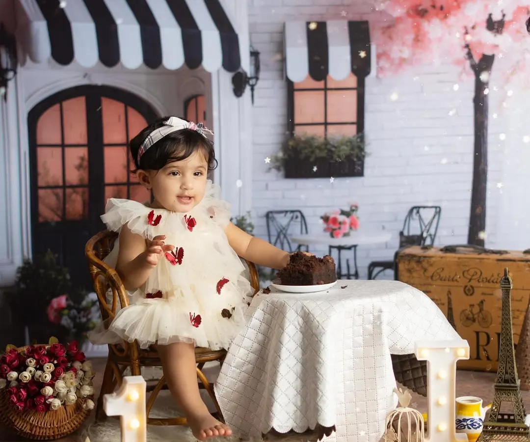 A first birthday celebration straight out of a Parisian dream. I design elaborate themed setups like this 'Cafe Paris' scene to make your baby's milestone truly unforgettable. We handle all the details, from the props to the cake, so you can just enjoy the moment.