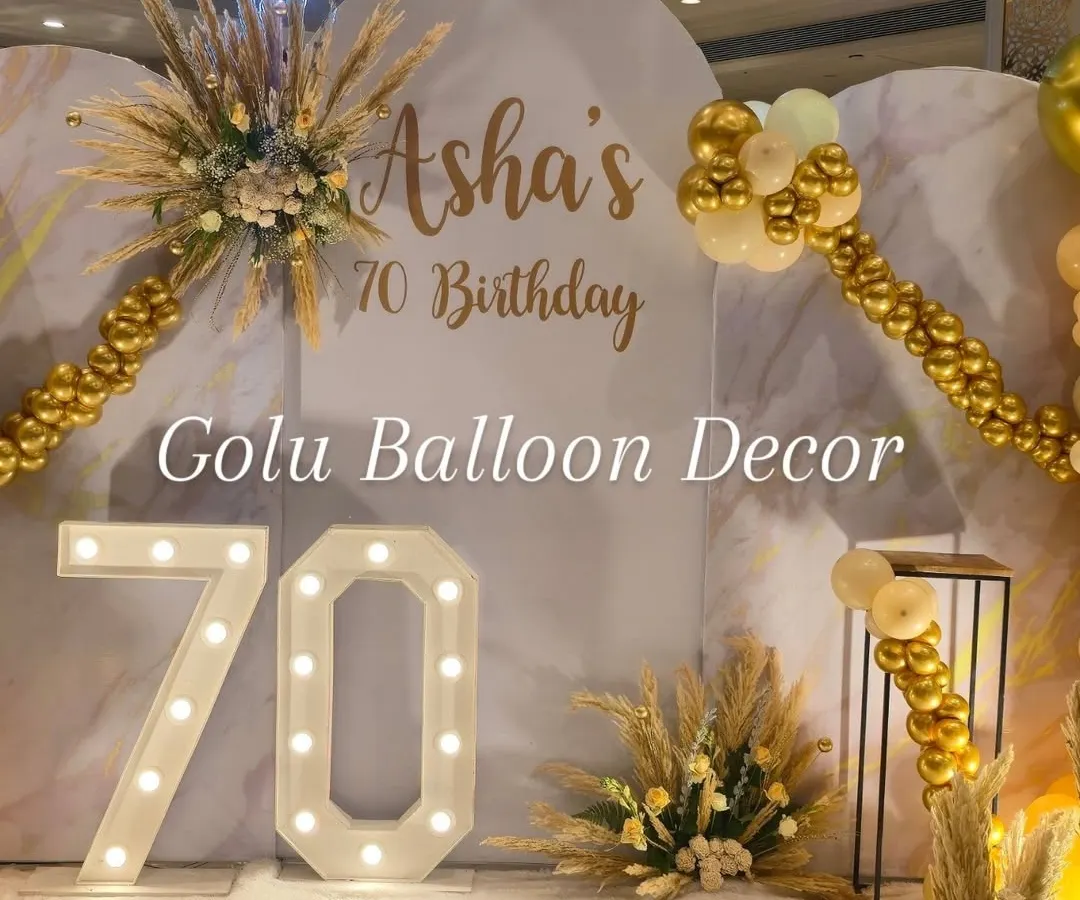 I design elegant and sophisticated setups for milestone birthdays, like this 70th celebration. This boho-chic theme uses a marble-finish backdrop, pampas grass arrangements, and large marquee numbers to create a classy and warm atmosphere.